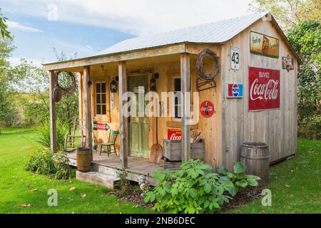 Ancien hangar de rangement en bois de pin de style rustique avec toit en tôle ondulée et décoré de Coca-Cola vintage et de 7up panneaux pour boissons. Banque D'Images