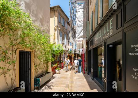 L'une des nombreuses rues et ruelles typiques de cafés et de boutiques colorés dans la ville historique de Saint-Rémy-de-Provence lors d'une belle journée d'été. Banque D'Images