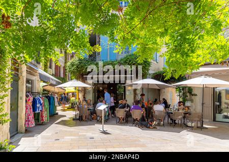 L'une des nombreuses rues et ruelles typiques de cafés et de boutiques colorés dans la ville historique de Saint-Rémy-de-Provence lors d'une belle journée d'été. Banque D'Images