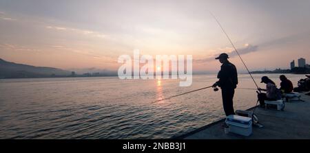 Tamsui, Taïwan - 12 février 2023 : personnes à la rivière Tamsui, rue Tamsui dans le quartier de tamsui, ville de New taipei, Taïwan pendant le coucher du soleil Banque D'Images