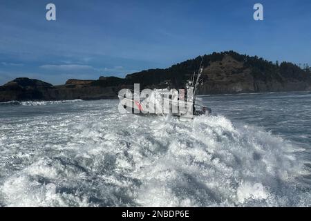 Un équipage de 47 pieds de canot de sauvetage motorisé de la station de garde côtière de Yaquina Bay répond à un rapport de plusieurs surfeurs en détresse qui étaient poussés contre des rochers près d'Agate Beachgate Beach, Oregon, le 12 février 2023. Un équipage d'hélicoptère MH-65 Dolphin de l'installation aérienne de la Garde côtière de Newport a transporté les trois personnes à terre, où des membres du service des incendies de Newport attendaient pour fournir de l'aide. (É.-U. Photo de courtoisie de la Garde côtière) Banque D'Images