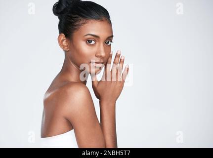 Une véritable lueur vient de l'intérieur. une belle jeune femme posant sur un fond blanc. Banque D'Images