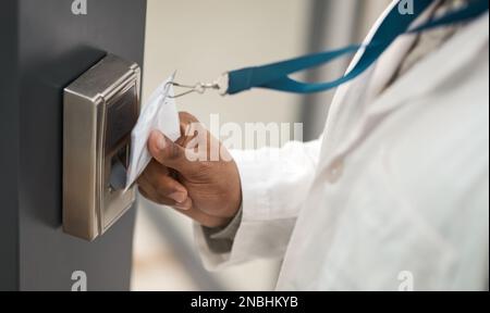 Aucune entrée sans identification. Gros plan d'un scientifique méconnaissable utilisant une carte d'accès pour entrer à une porte. Banque D'Images