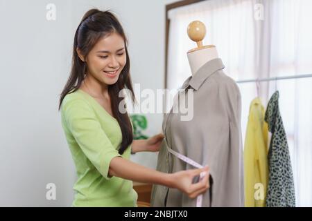 Mode vêtements marchand concept, Femme vendeur présenter nouvelle robe et mesurer la taille de coffre de la chemise. Banque D'Images