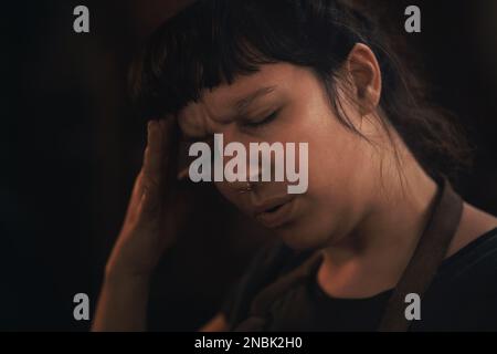 La fatigue vous coûte votre force mentale. une jeune femme éprouvant du stress en travaillant dans une fonderie. Banque D'Images