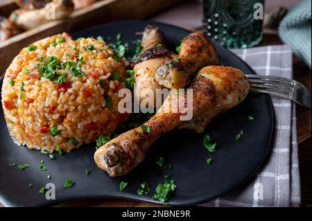 Pilons de poulet avec du riz djuvec serbe sur une assiette Banque D'Images