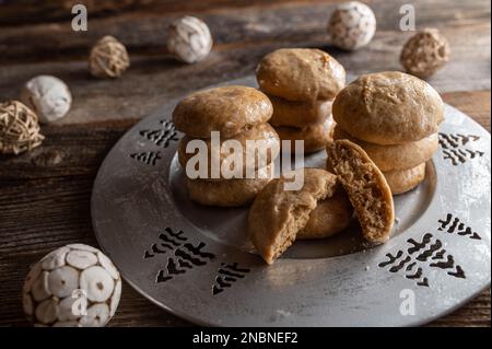 Petits gâteaux au pain d'épice frais et faits maison cuits sur une plaque argentée sur fond de bois Banque D'Images