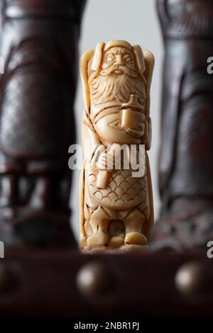 Pièces d'échecs orientales chinoises, avec le roi empereur blanc entre deux pièces noires. Jeu d'échecs et planche antiques Banque D'Images