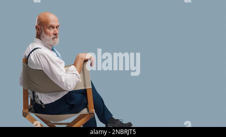 Réalisateur professionnel confiant assis sur la chaise du réalisateur et regardant la caméra : école de théâtre, production vidéo et concept de l'industrie cinématographique, blana Banque D'Images