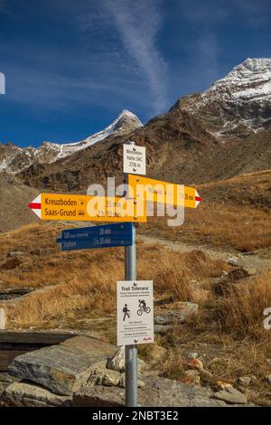 Un panneau directionnel en bois avec des flèches pointant dans plusieurs directions dans les Alpes suisses Banque D'Images