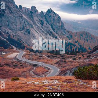 Vue d'automne brumeuse du parc national de Tre Cime Di Lavaredo avec une route sinueuse. Scène nocturne spectaculaire des Alpes Dolomites, à Auronzo Di Cadore, en Italie Banque D'Images