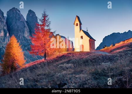 Scène d'automne illuminée du lieu de culte - Kapelle Ciapela. Vue majestueuse en soirée sur Gardena Pass. Coucher de soleil coloré dans les Alpes Dolomites, Italie, Europe Banque D'Images