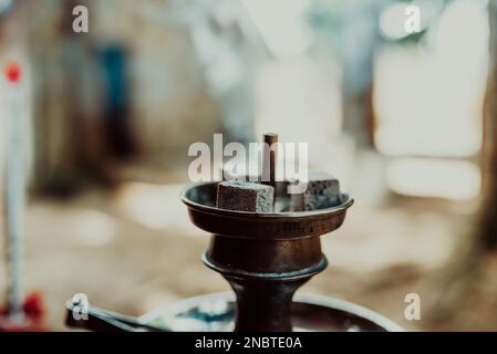 Shisha nargua avec des charbons chauds rouges. Étincelles provenant de la respiration. Image en tons. Le narguilé moderne avec charbon de coco pour se détendre et la fumée de shisha. L'ankylostome et les étincelles Banque D'Images