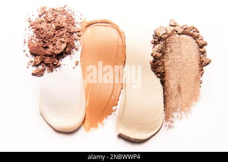 Sur un fond blanc, fabriquer des échantillons de poudre brun, de beige, de couleur peau et de crème beige clair. Banque D'Images