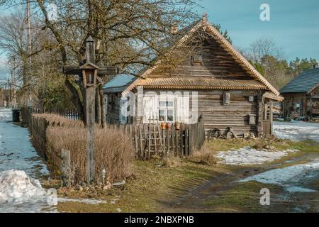 Belle ancienne maison traditionnelle en bois dans le village de Margionys, région de Dzūkija ou Dainava, Lituanie, en hiver ou au printemps Banque D'Images