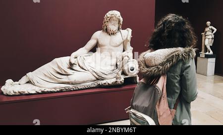 Curieuse jeune femme touriste regardant l'exposition dans le musée dans la galerie moderne. Voyageur dans le centre d'art, statue historique. Éducation et divertissement Banque D'Images