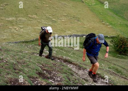 Deux hommes (randonneurs) marchant sur le sentier jusqu'à Parkhouse Hill à partir de près de Glutton Bridge dans la vallée de Dove, Peak District National Park, Angleterre, Royaume-Uni. Banque D'Images