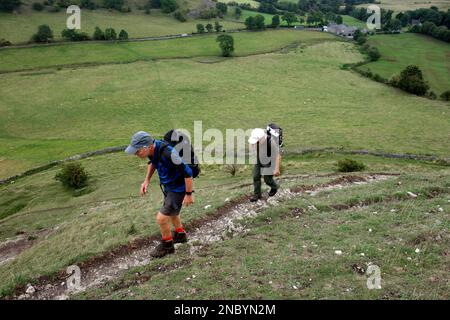 Deux hommes (randonneurs) marchant sur le sentier jusqu'à Parkhouse Hill à partir de près de Glutton Bridge dans la vallée de Dove, Peak District National Park, Angleterre, Royaume-Uni. Banque D'Images
