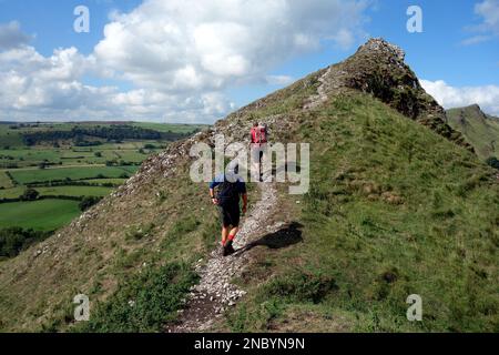 Deux hommes (randonneurs) marchant sur Ridge Path jusqu'à Parkhouse Hill à partir de près de Glutton Bridge dans la Dove Valley, Peak District National Park, Angleterre, Royaume-Uni. Banque D'Images