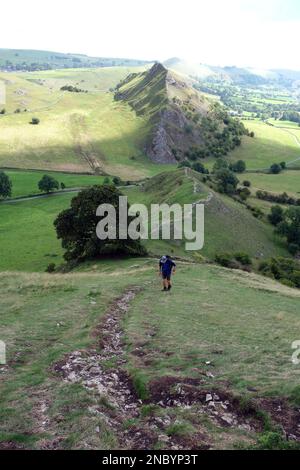 Homme marchant sur le sentier Ridge de Chrome Hill avec Parkhouse Hill en arrière-plan dans la Dove Valley, Peak District National Park, Angleterre, Royaume-Uni. Banque D'Images