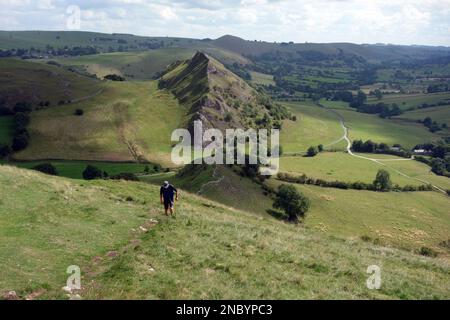 Homme marchant sur le sentier Ridge de Chrome Hill avec Parkhouse Hill en arrière-plan dans la Dove Valley, Peak District National Park, Angleterre, Royaume-Uni. Banque D'Images