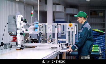 CHERKASY, UKRAINE - 24 AOÛT 2018 : travailleur de l'équipement d'impression, ajuste, réglemente le processus d'impression. processus de travail de l'impression des colis pour les céréales, les produits agricoles. Photo de haute qualité Banque D'Images