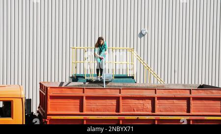 CHERKASY, UKRAINE - 24 AOÛT 2018 : une femme, employée d'une entreprise agricole, prélève des échantillons de grains et de graines de tournesol dans un tube pour analyse en laboratoire. Photo de haute qualité Banque D'Images