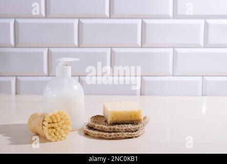 Détergent liquide, éponges naturelles brosse pour laver la vaisselle et les ustensiles de cuisine sur la table de cuisine Banque D'Images
