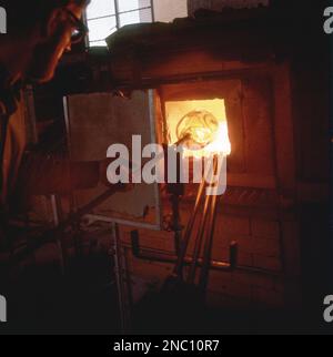 1969, historique, un morceau de verre est passé à l'intérieur d'un four à la Mdina Glassworks, Malte, établie en 1968 comme le tout premier fabricant de verrerie de l'île méditerranéenne. Banque D'Images