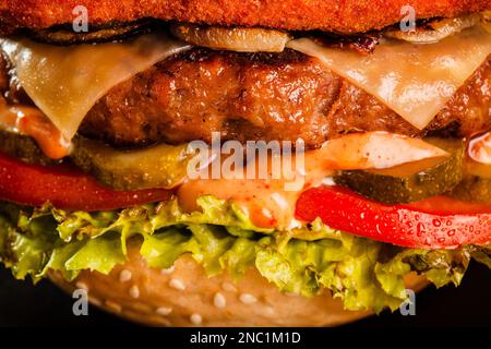 Double hamburger avec bacon grillé fromage jaune oignons tomates concombres et laitue. Résumé de la restauration rapide. Banque D'Images