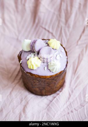 Un paska traditionnel décoré de chocolat blanc suisse et de meringue se dresse sur une nappe de lavande. Vacances de Pâques Banque D'Images