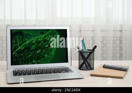 Ordinateur portable moderne et fournitures sur une table en bois à l'intérieur Banque D'Images