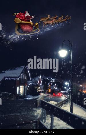 La veille magique de Noël. Père Noël avec rennes volant dans le ciel Banque D'Images