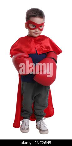Joli petit garçon en costume super-héros et gants de boxe sur fond blanc Banque D'Images