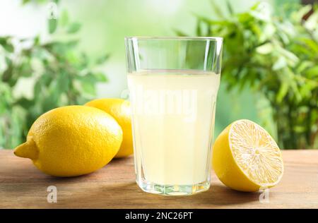 Jus de citron fraîchement pressé sur une table en bois Banque D'Images