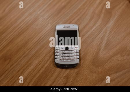 Ancien et ancien téléphone BlackBerry de 2013 sur fond de bois Banque D'Images