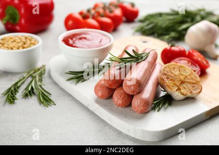 Délicieuses saucisses végétariennes au romarin et aux légumes sur table grise Banque D'Images