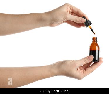 Femme qui goutte de l'iode médical dans une bouteille sur fond blanc, gros plan Banque D'Images