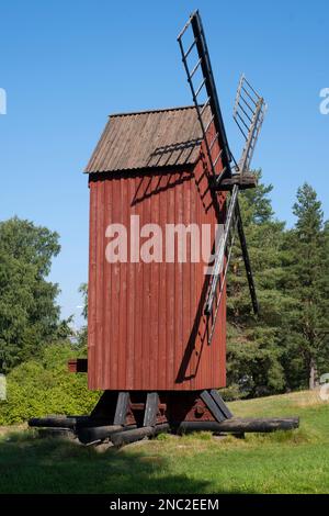 Helsinki / Finlande - 14 AOÛT 2022 - et ancien moulin à vent rouge avec des lames de bois contre un ciel bleu vif Banque D'Images