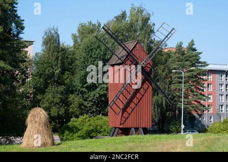 Helsinki / Finlande - 14 AOÛT 2022 - ancien moulin à vent en bois rouge avec une botte de foin au premier plan. Agriculture finlandaise. Banque D'Images