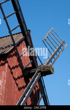 Helsinki / Finlande - 14 AOÛT 2022 - et ancien moulin à vent rouge avec des lames de bois contre un ciel bleu vif Banque D'Images