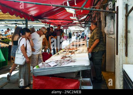 Les gens qui achètent la prise du jour à un stand de poisson du marché du Rialto sur la place Campo della Pescaria, sestiere de San Polo, Venise, Vénétie, Italie Banque D'Images