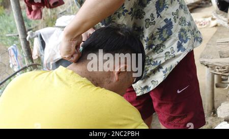 Jeune homme dans salon de coiffure Service de coiffure concept , coiffure ou salon de coiffure peigne les cheveux de l'homme tout en faisant une coiffure dans le salon de coiffure moderne Banque D'Images