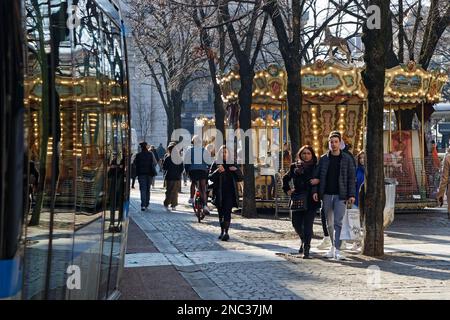 GRENOBLE, FRANCE, 8 février 2023 : le Merry-Go-round se reflète sur les fenêtres du tramway lors d'une journée de forte affluence dans le centre-ville. Banque D'Images