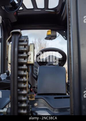 gros plan de la chaîne de levage sur un chariot élévateur avec commandes de direction derrière Banque D'Images