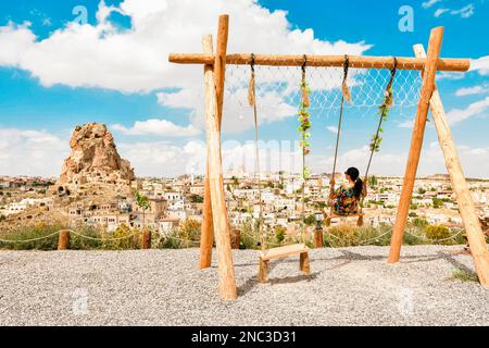 Femme touriste balançant en Cappadoce en vacances. Château d'Uchisar, ville de Cappadoce, Turquie près de Göreme. Cappadoce paysage et vallée avec antique Banque D'Images