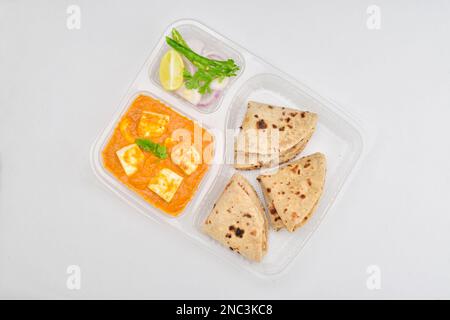 Shahi paneer et tawa roti servis avec une salade d'oignons dans des thali jetables, concept de service de déjeuner Banque D'Images