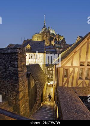 France. Normandie. Manche (50) Mont Saint Michel - le village : entre deux maisons bordant la passerelle sud, un petit escalier menant au mai Banque D'Images