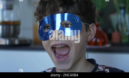 Portrait d'un enfant portant un masque bleu sur les yeux. Amusant beau jeune garçon gros plan enfant oeil avec masque de carnaval Banque D'Images