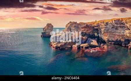 Lonly homme sur le bord des falaises de Tyulenovo. Incroyable lever de soleil sur la mer Noire. Pittoresque scène matinale de Bulgarie, Europe. Concept de voyage backgro Banque D'Images